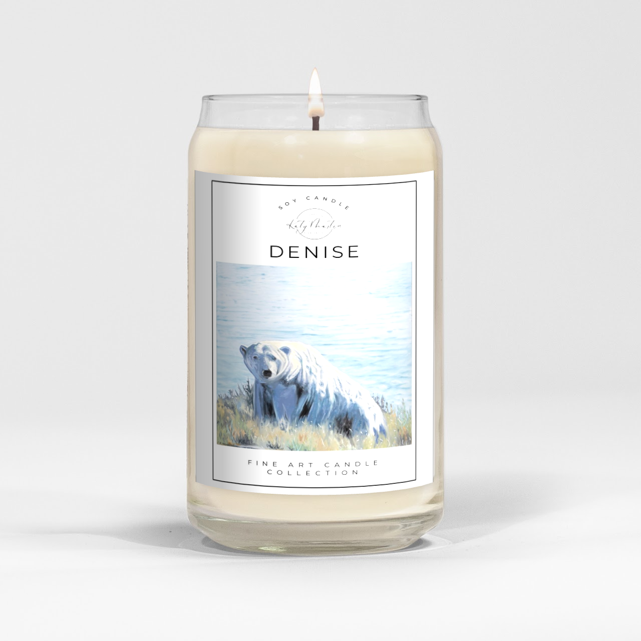 close up of burning white wax candle in a clear glass vessel with fine art polar bear painting by Manitoba Artist Katy Martin on label