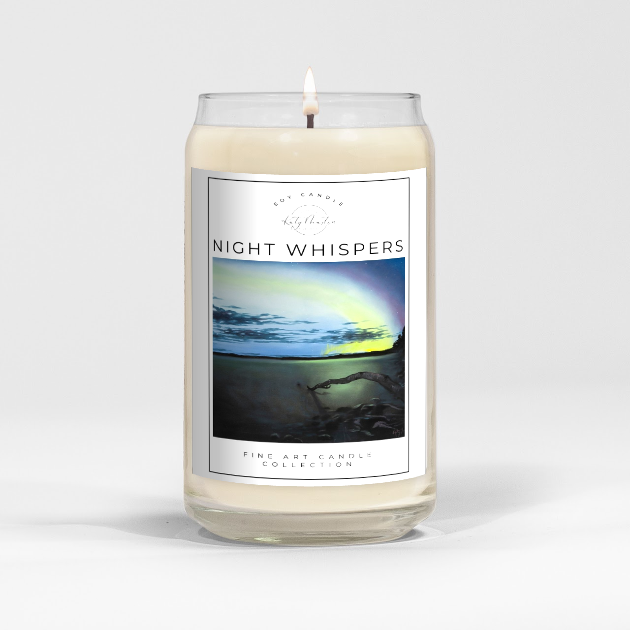 close up of burning white wax candle in a clear glass vessel with fine art landscape painting of the northern lights by Manitoba Artist Katy Martin on label