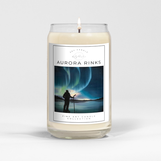 close up of burning white wax candle in a clear glass vessel with fine art landscape painting by Manitoba Artist Katy Martin on label